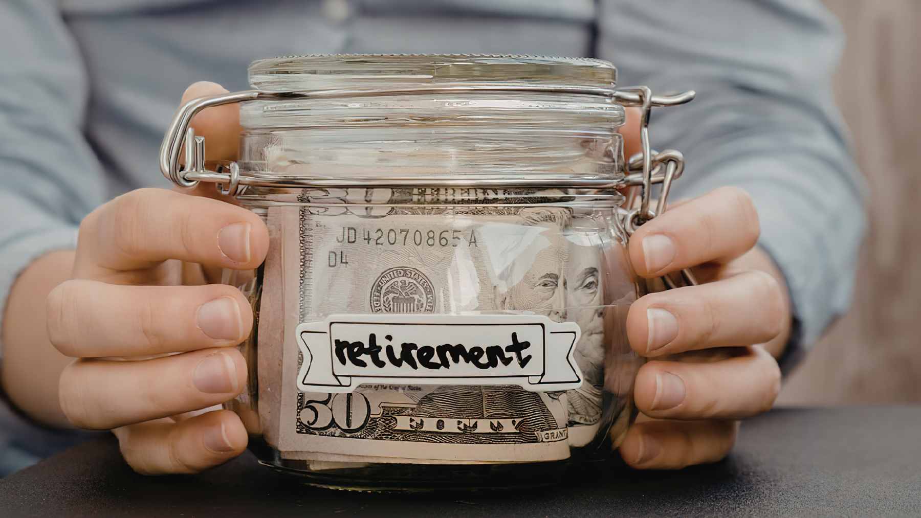 An older worker reviewing financial documents and retirement savings plans at a desk.