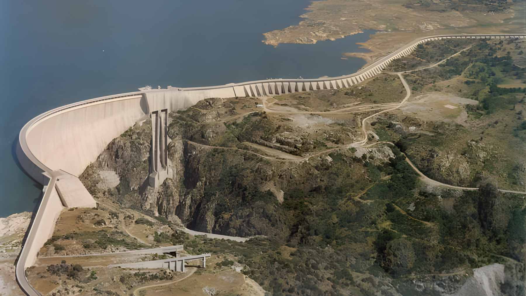Aerial view of the Almendra Dam's massive concrete arch wall and the Tormes River canyon in Spain.