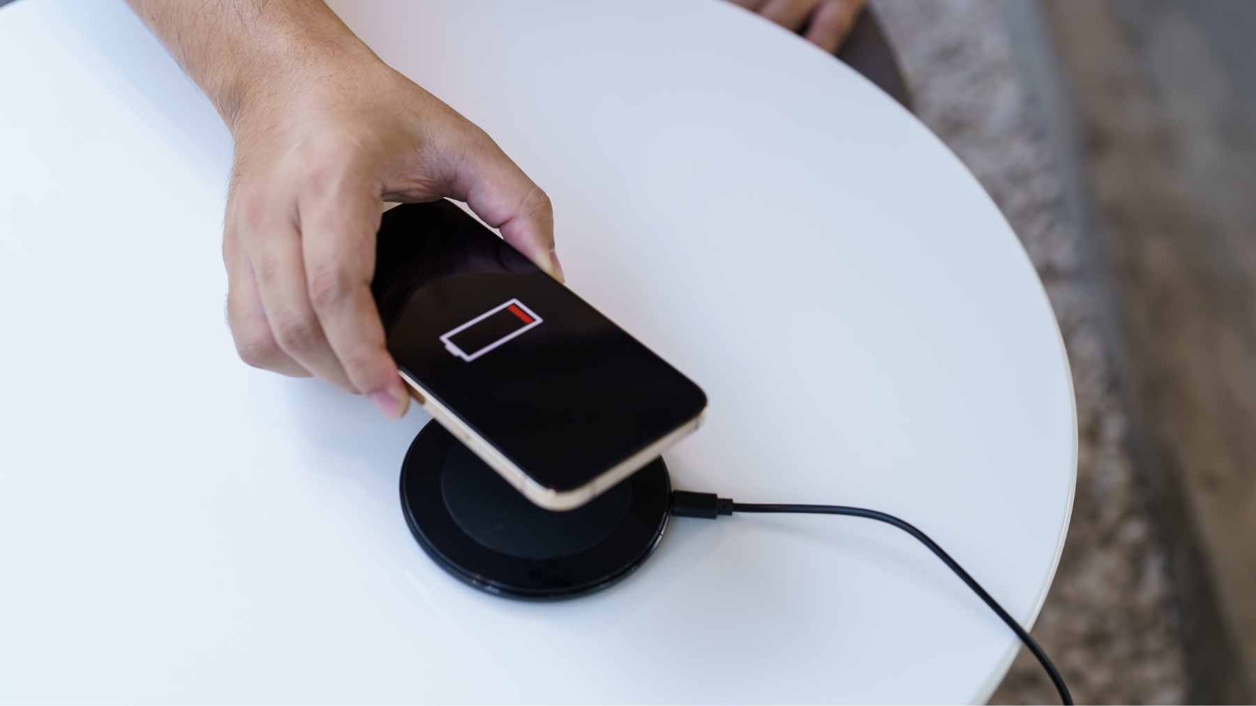 A sleek, ultra-thin concept smartphone without a charging port, utilizing a magnetic wireless power bank attached to its back.