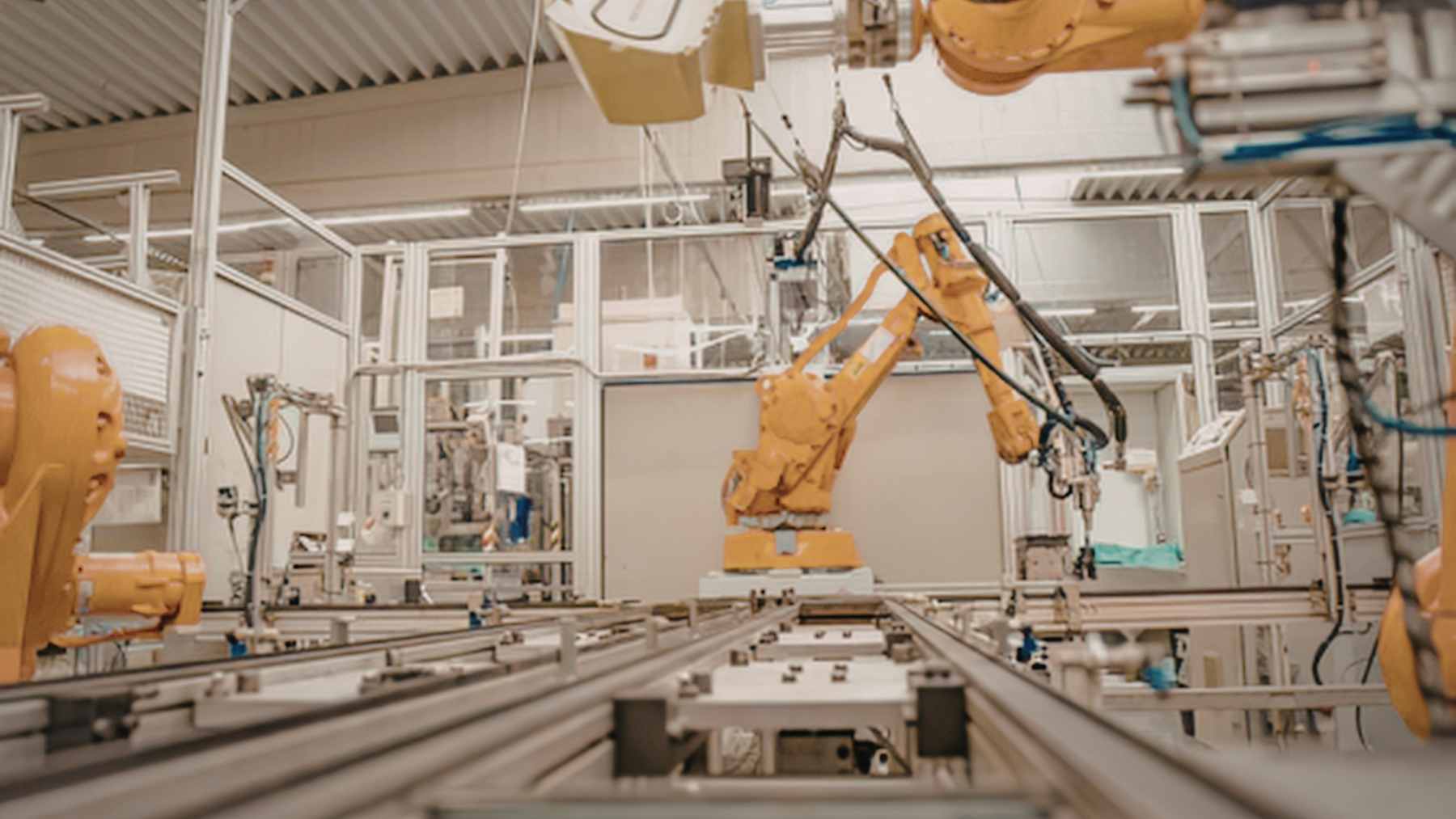 Jeff Bezos aims to raise $100 billion to buy factories and rebuild them with AI, and the move could quietly reshape American manufacturing faster than anyone expected 1 An advanced automated factory floor featuring robotic arms and AI-integrated assembly lines for semiconductor and aerospace parts.