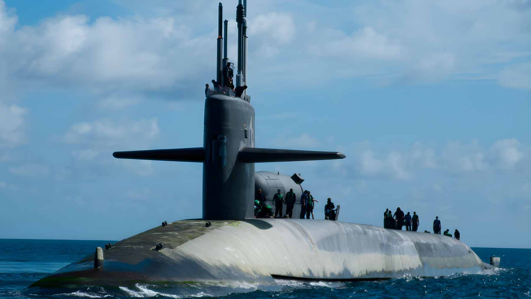 A side-view illustration of an Ohio-class guided-missile submarine (SSGN) showing multiple Tomahawk cruise missiles launching from its vertical tubes.