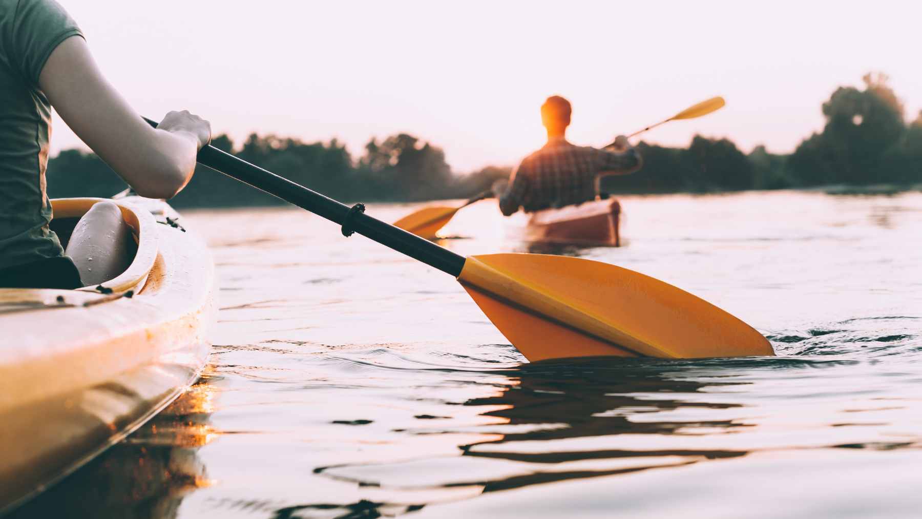 A kayaker paddling on a calm Oregon river, representing the type of small craft now required to carry a Waterway Access Permit.
