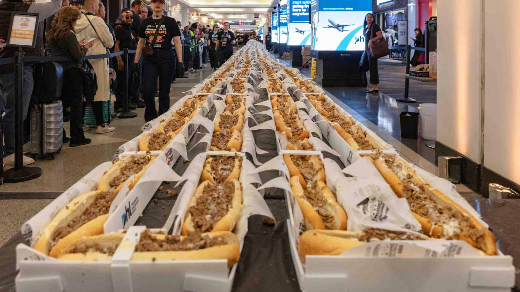 A Guinness World Record attempt showing a continuous line of 1,291 cheesesteaks stretching through the Terminal B-C concourse at Philadelphia International Airport.