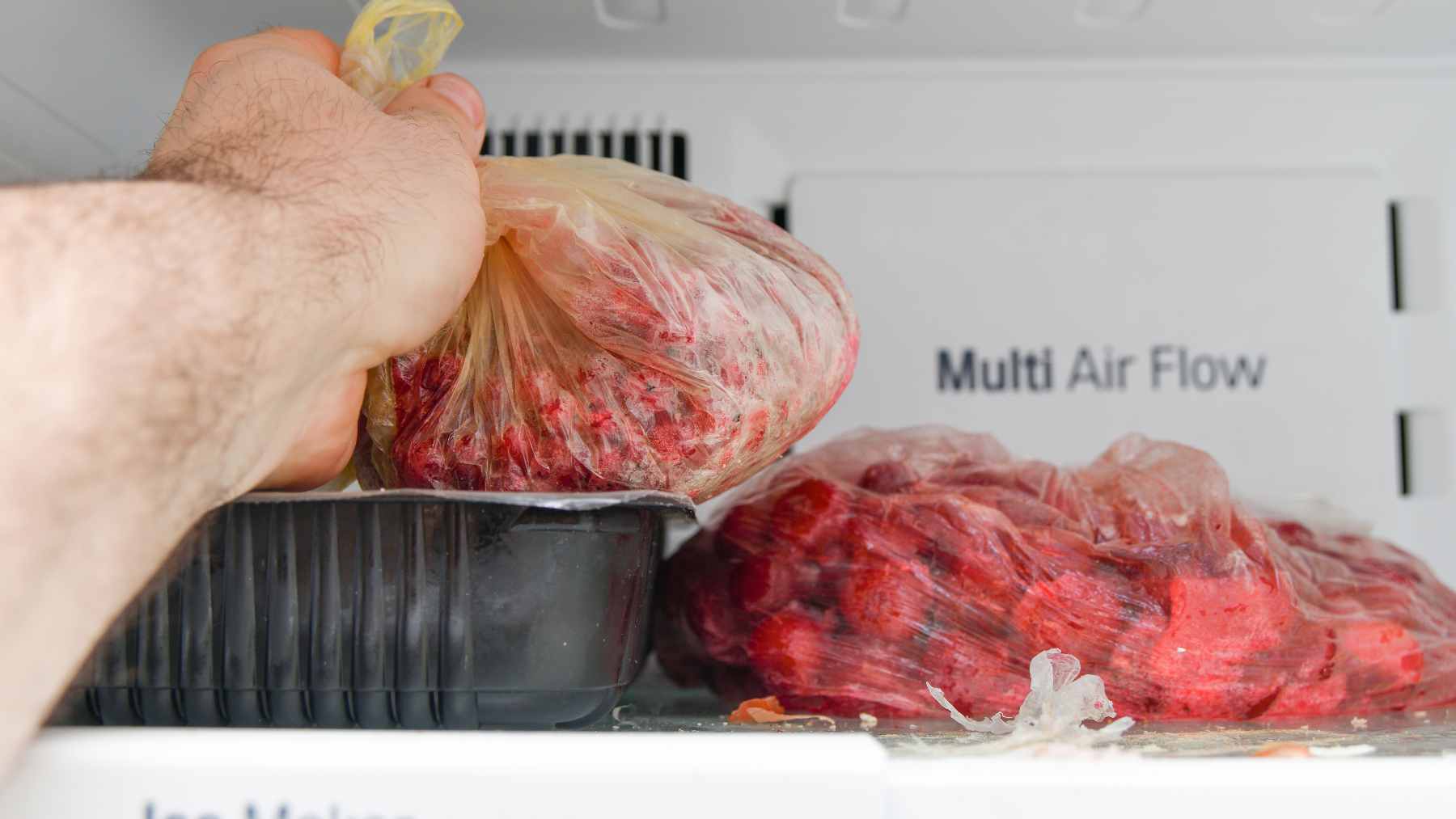 Keeping raw meat in a plastic bag may be ruining it faster than you think, and the fridge habit almost everyone repeats could be hurting flavor and safety 1 Raw red meat sitting inside a thin, translucent plastic grocery bag on a refrigerator shelf, demonstrating improper storage.