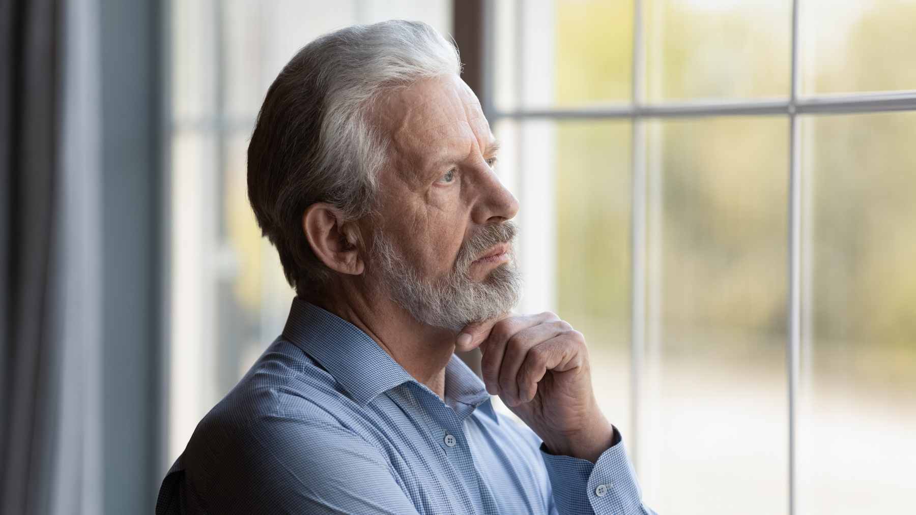 A retired man sitting alone in a quiet living room, reflecting on the transition from a busy career to a sedentary lifestyle.