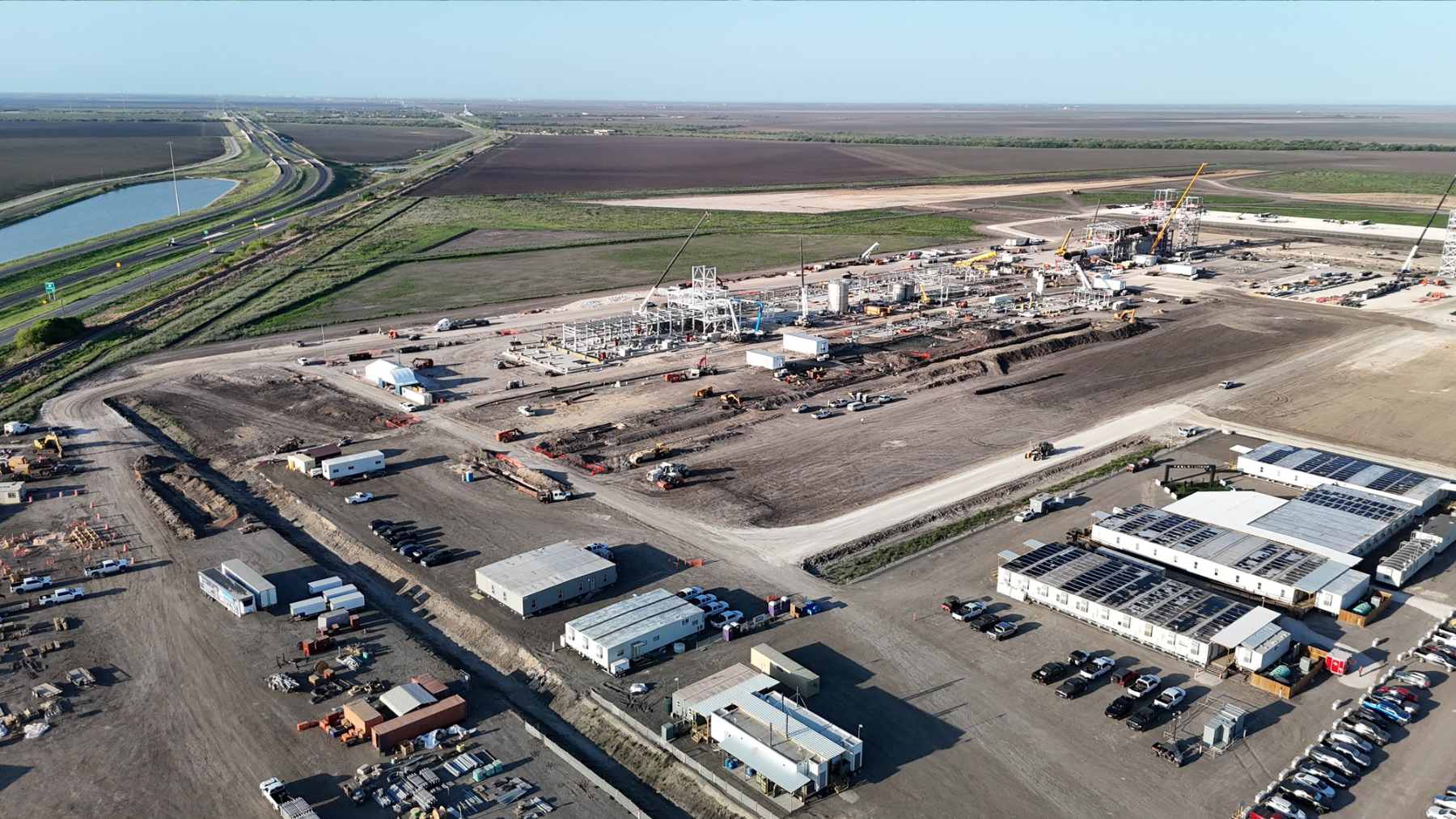 An industrial drainage pipe discharging dark wastewater into a roadside ditch near the Tesla lithium refinery in Robstown, Texas.