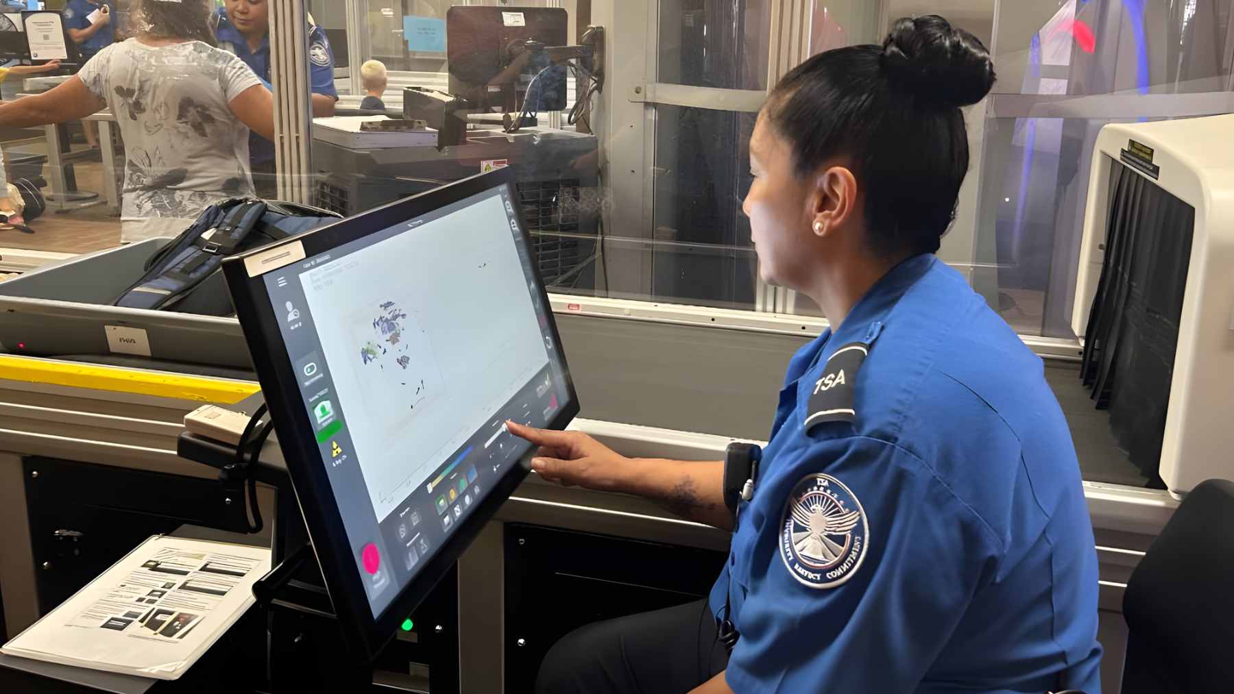 A passenger at a TSA airport security checkpoint holding a smartphone showing a $45 ConfirmID payment receipt.