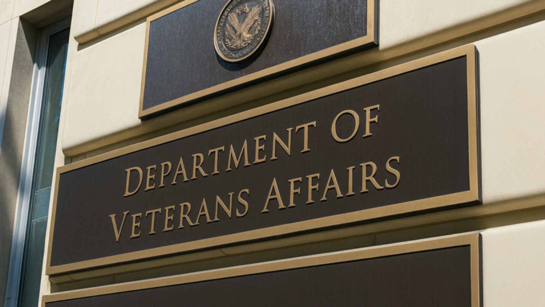 A military veteran sitting at a kitchen table, carefully reviewing a Department of Veterans Affairs disability benefits letter.