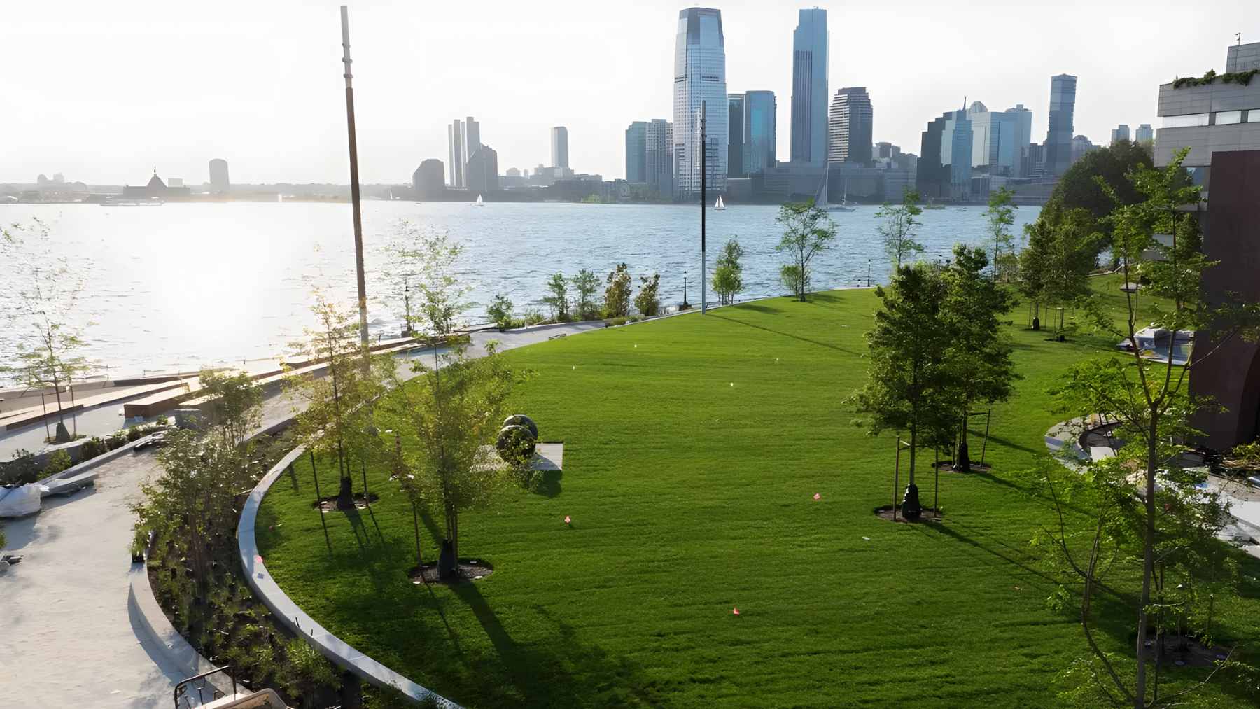 Interior of The Classroom at Wagner Park Pavilion in Battery Park City, featuring floor-to-ceiling windows with views of the New York Harbor and Statue of Liberty.