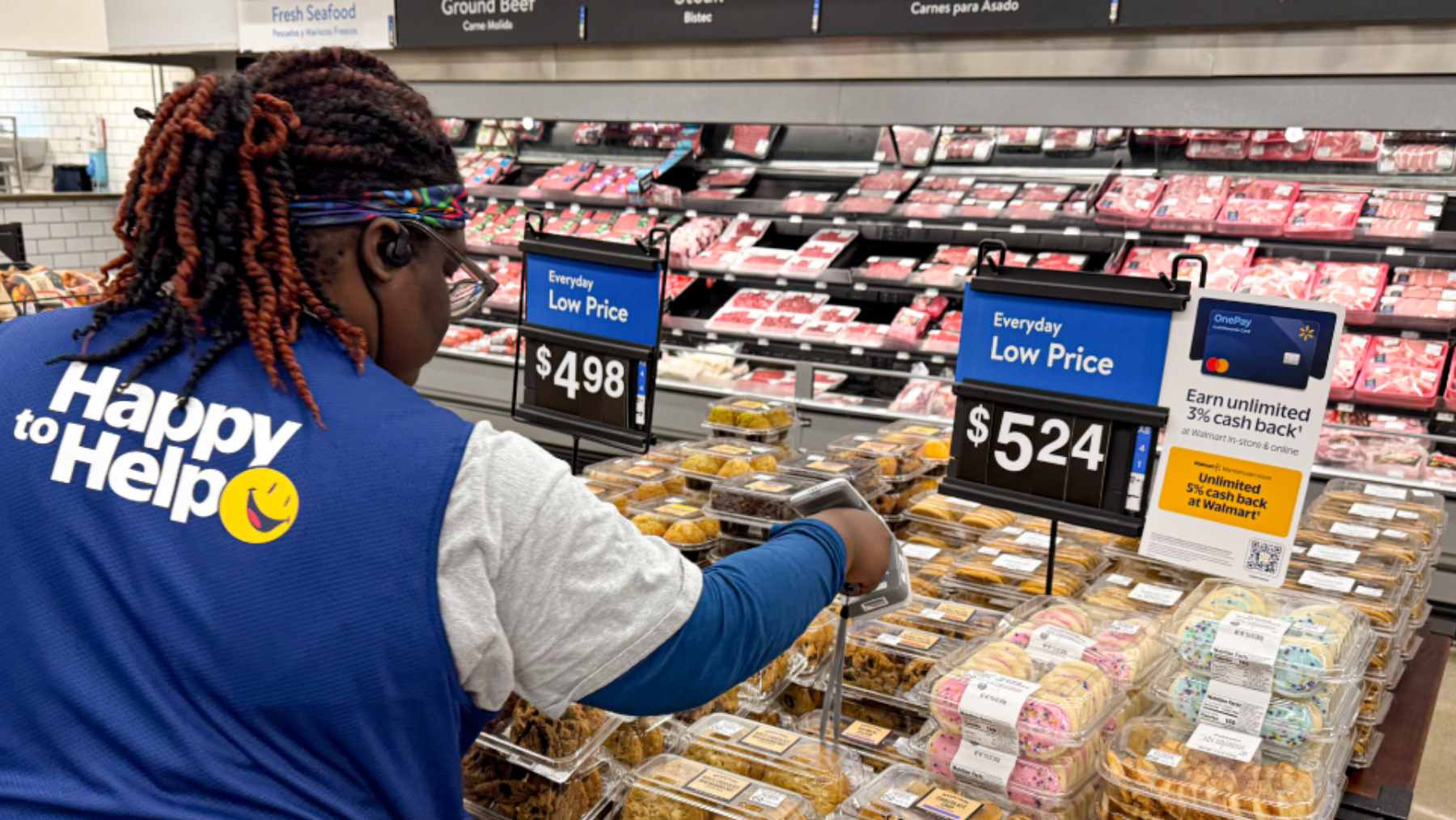 A Walmart self-checkout area with several closed lanes and an employee monitoring the active registers to prevent shoplifting.