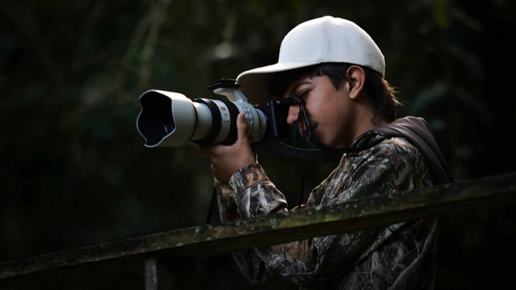 A 14-year-old boy explaining his educational bird conservation board game to a group of interested players.