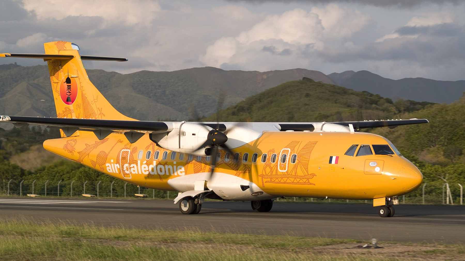 An Air Calédonie ATR 72-600 turboprop passenger plane parked on a regional runway in New Caledonia.