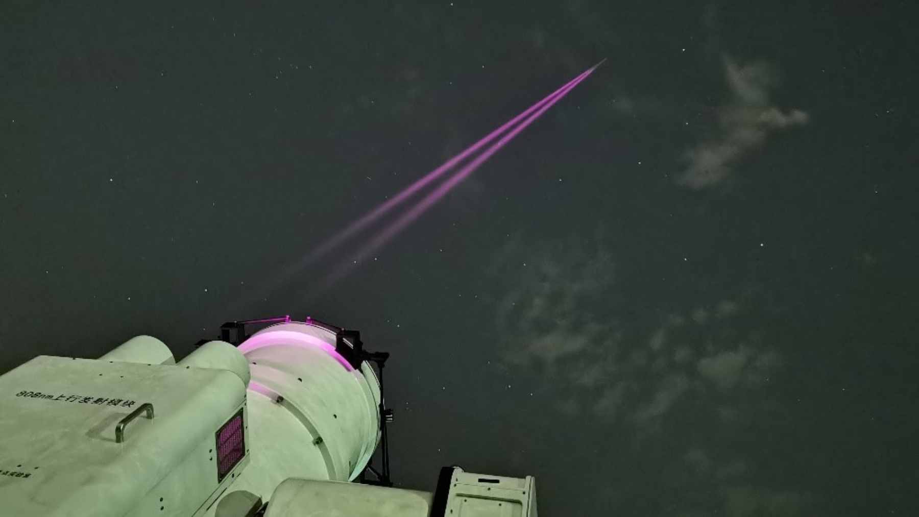 A large observatory telescope in Lijiang, China, receiving a high-speed laser data transmission from a satellite in geosynchronous orbit.