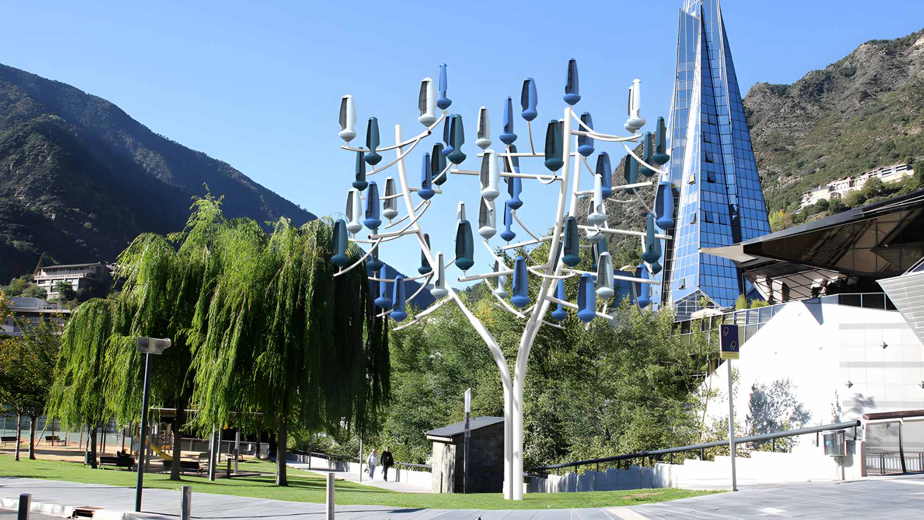 A 33-foot steel wind tree structure featuring 36 green, leaf-shaped microturbines installed in a residential backyard.