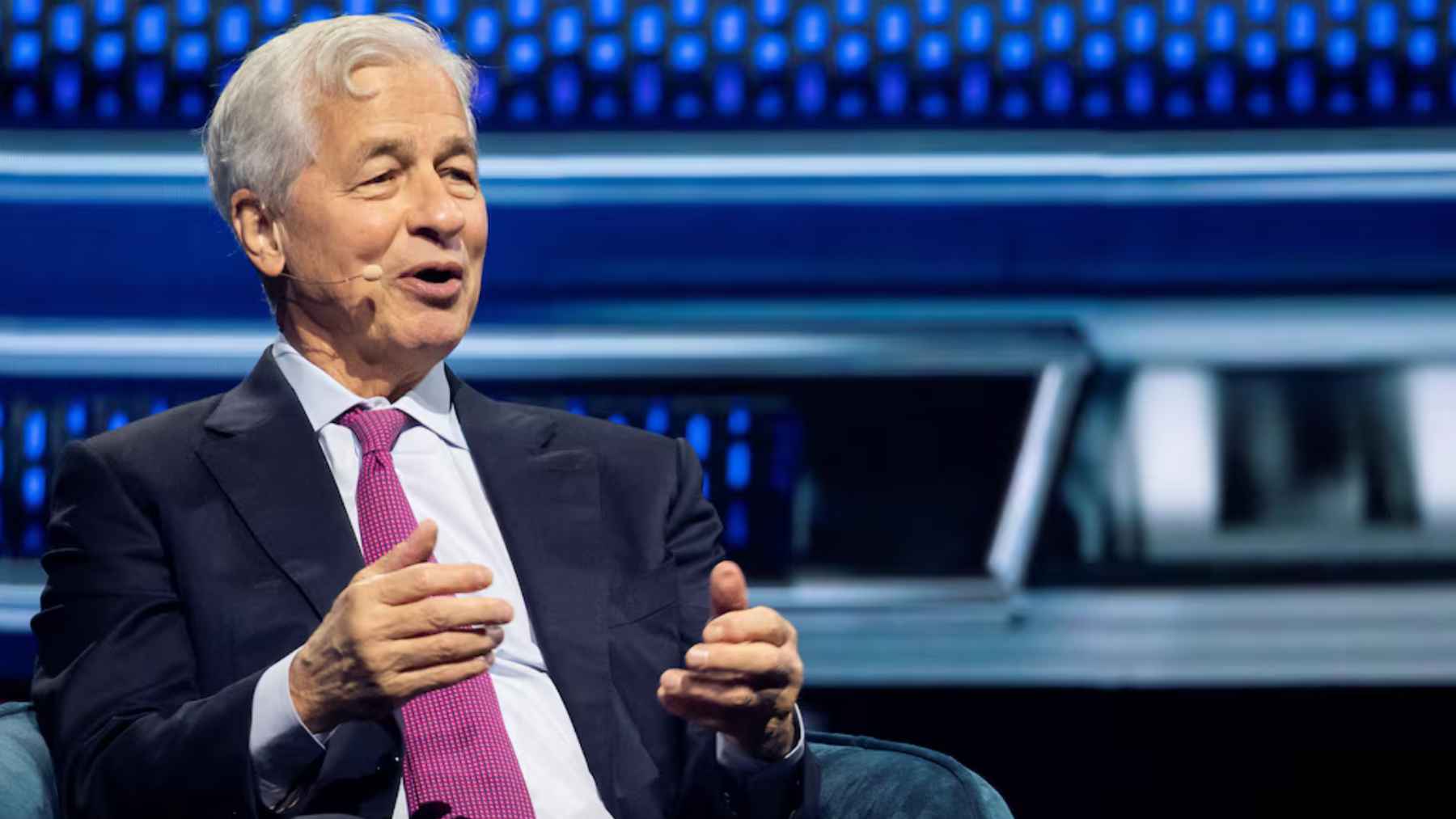 Bank executive speaking on stage during a discussion about remote work, younger employees, and screen-based work culture