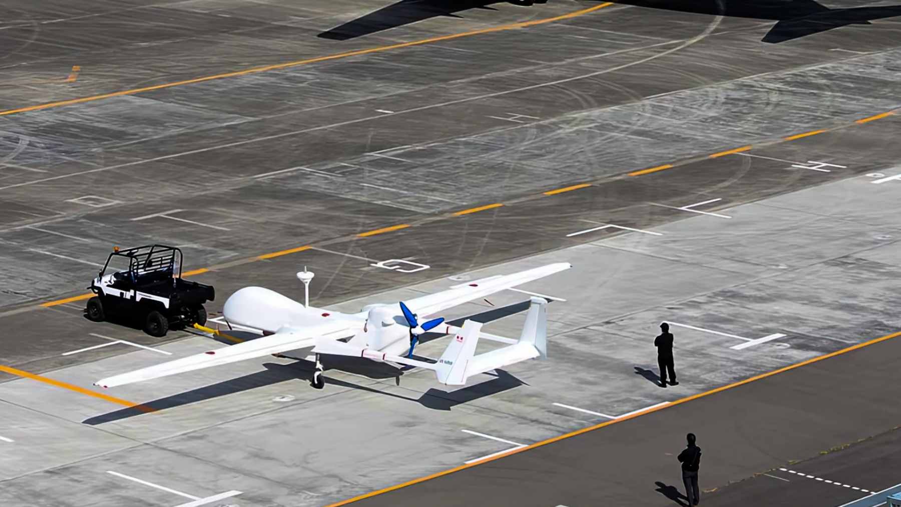 A medium-altitude military drone flying on a reconnaissance mission, representing Japan's shift toward unmanned aerial vehicles.
