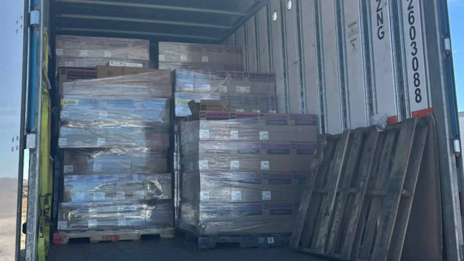 An opened LEGO box on a retail returns counter, revealing several plastic bags filled with dried pasta instead of toy bricks.