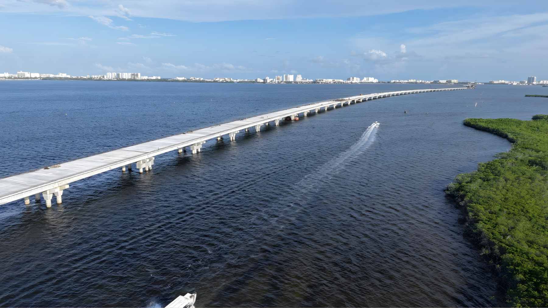 An aerial view of the Puente Vehicular Nichupté under construction, stretching across the Nichupté Lagoon system to connect downtown Cancun with the Hotel Zone.