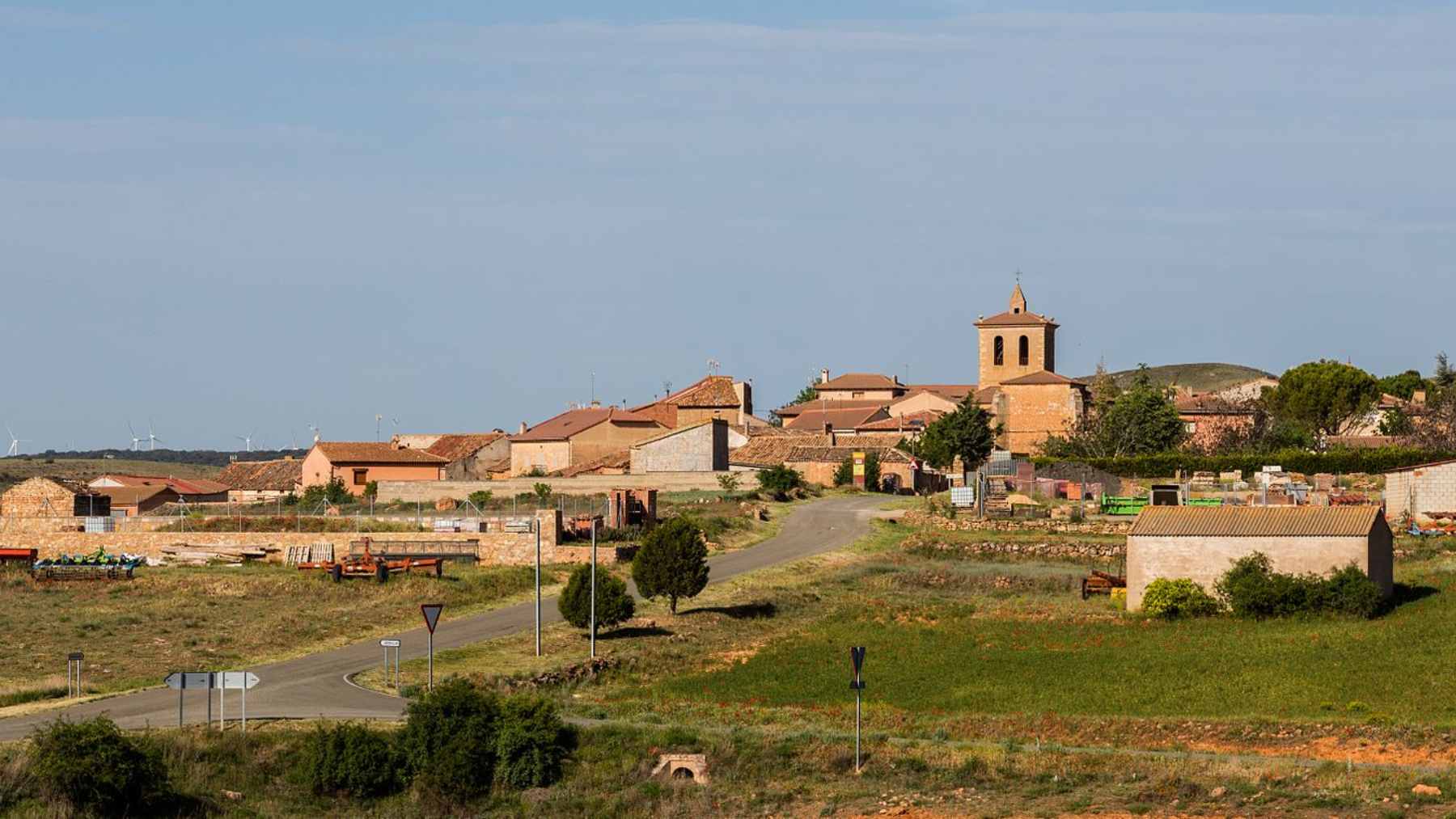 A scenic, quiet Spanish mountain village featuring traditional stone houses surrounded by dense rural forests.