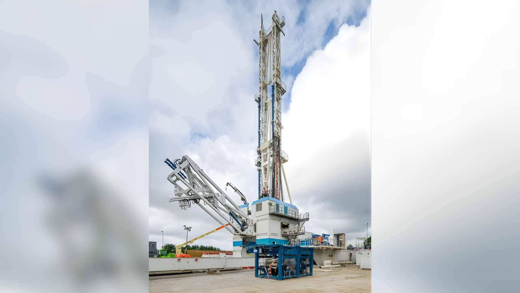 A wide view of the United Downs deep geothermal energy facility in Cornwall, featuring metal pipelines and vapor cooling systems against an overcast sky.