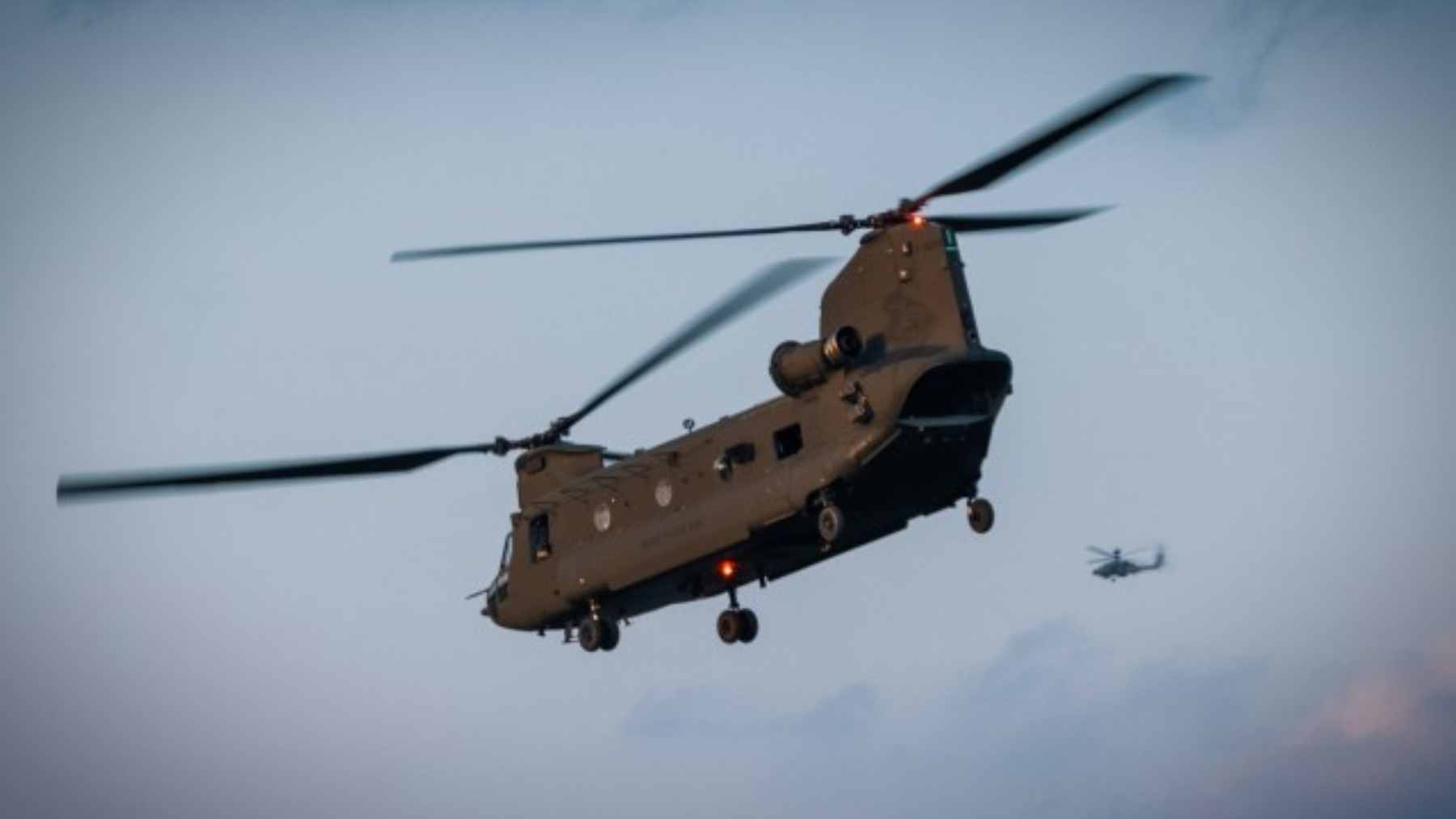 A U.S. Army CH-47F Chinook helicopter performing an automated landing in a dusty environment.