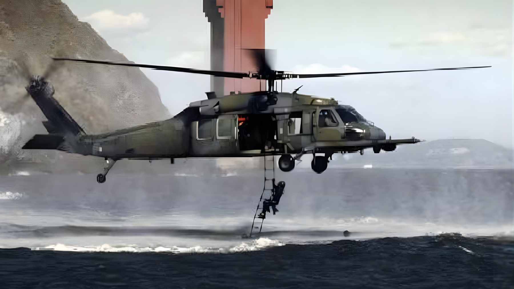 A U.S. military search and rescue helicopter hovering over rugged terrain during a high-stakes recovery mission.