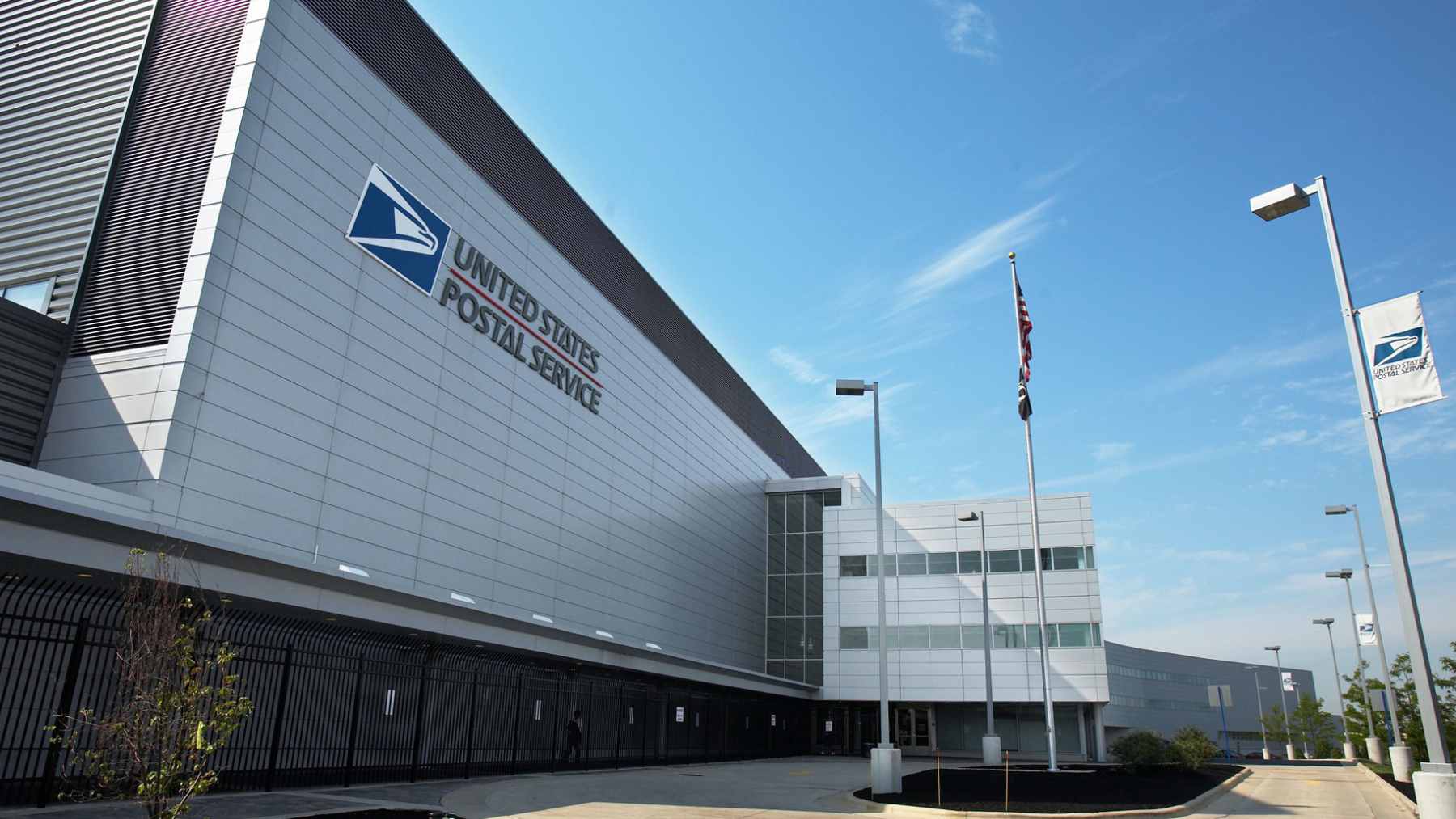 A white United States Postal Service delivery truck parked on a residential street during a package delivery route.
