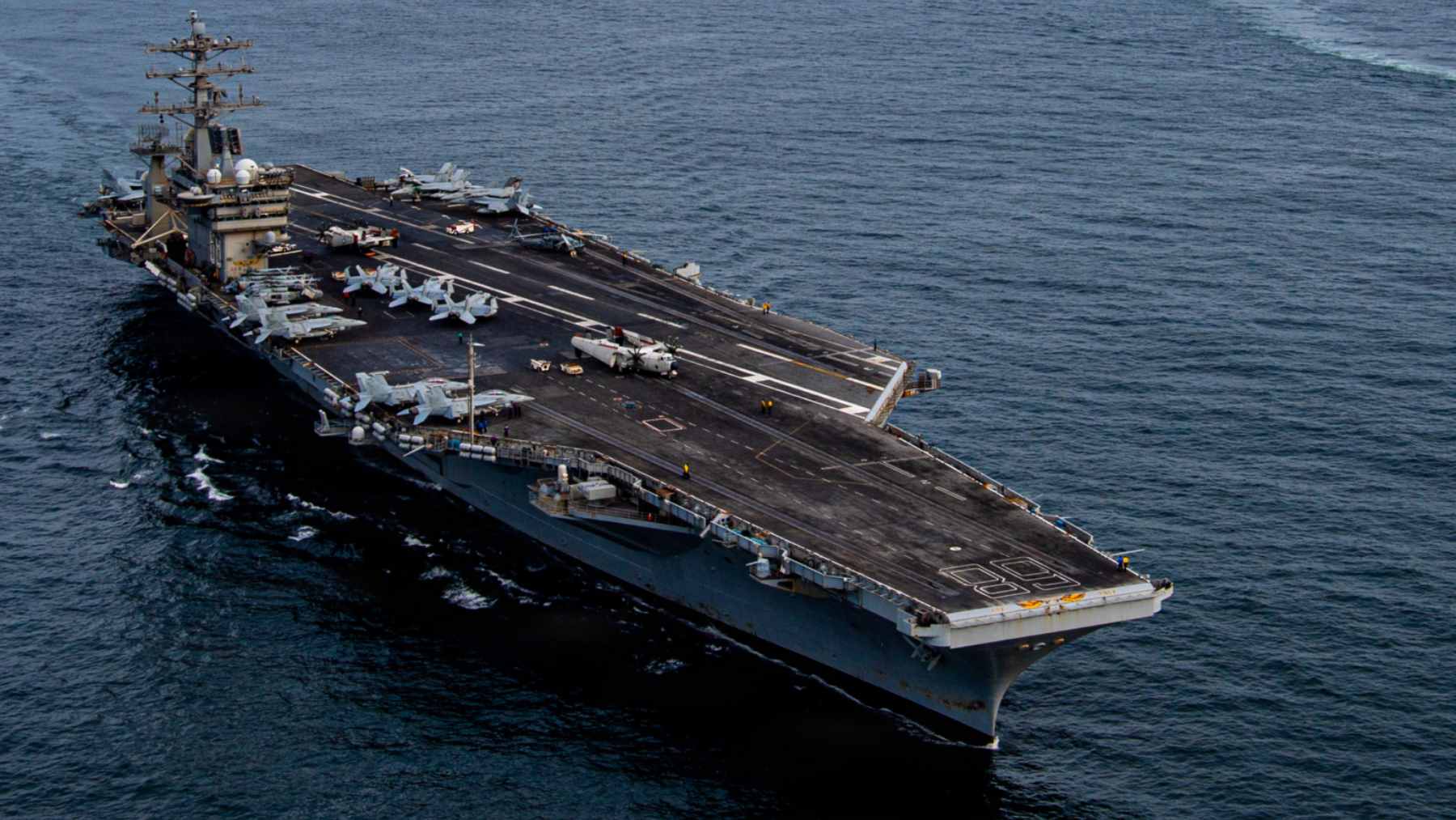 The nuclear-powered aircraft carrier USS Nimitz navigating the open ocean alongside a guided-missile destroyer during a maritime exercise.