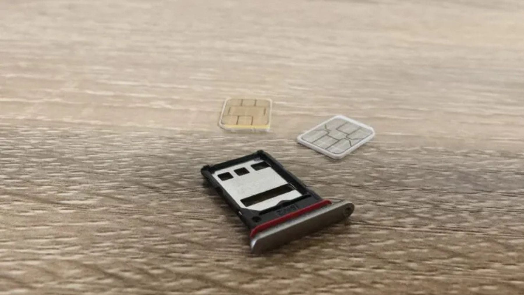 Bandeja SIM con tarjetas nanoSIM fuera del móvil, relacionada con el nuevo sistema de desbloqueo automático del PIN en Android 17.