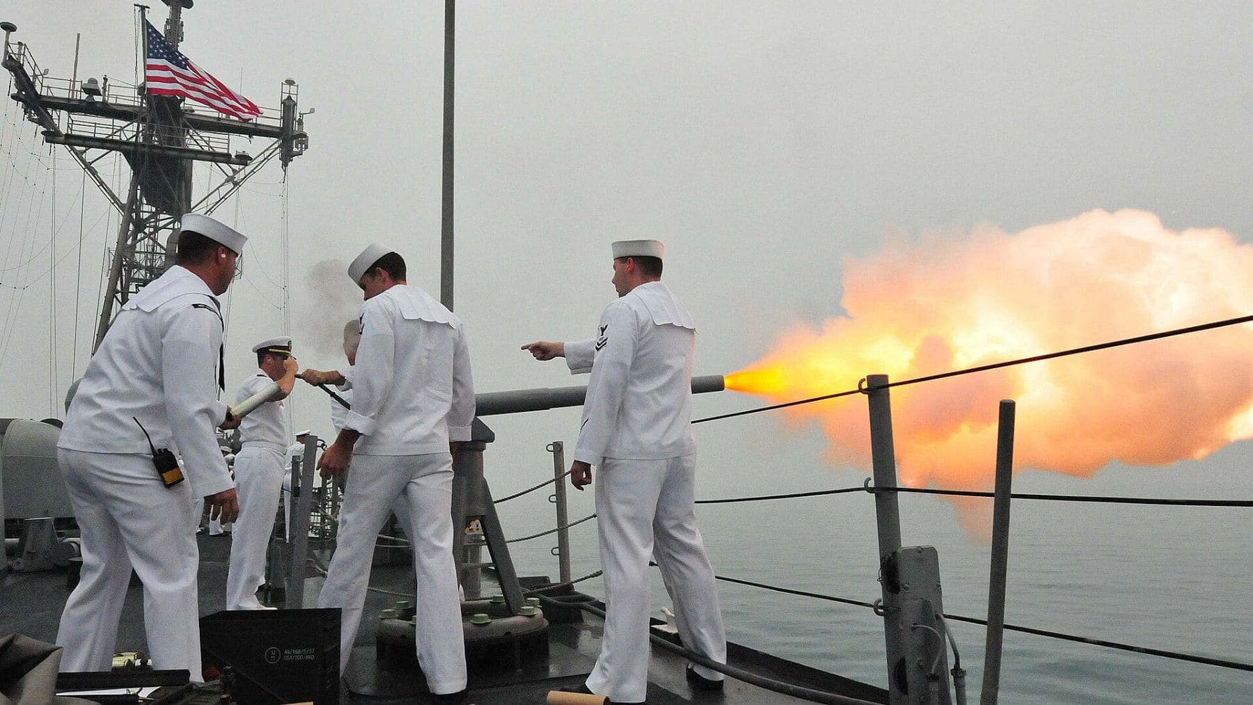 Militares de Estados Unidos disparan un cañón en un buque naval durante operaciones en el Pacífico.